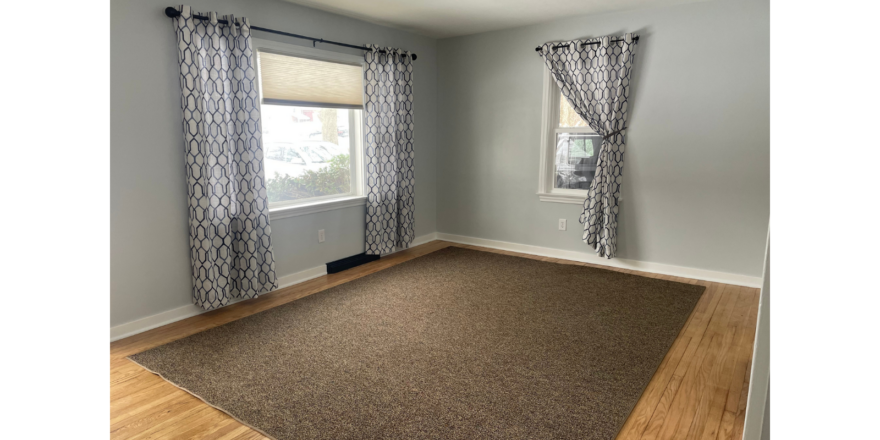 a living room with a rug and a window