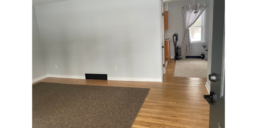a living room with hard wood floors and white walls