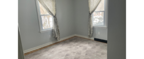 a empty room with two windows and a carpeted floor