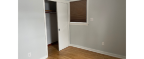 an empty room with a closet and a window