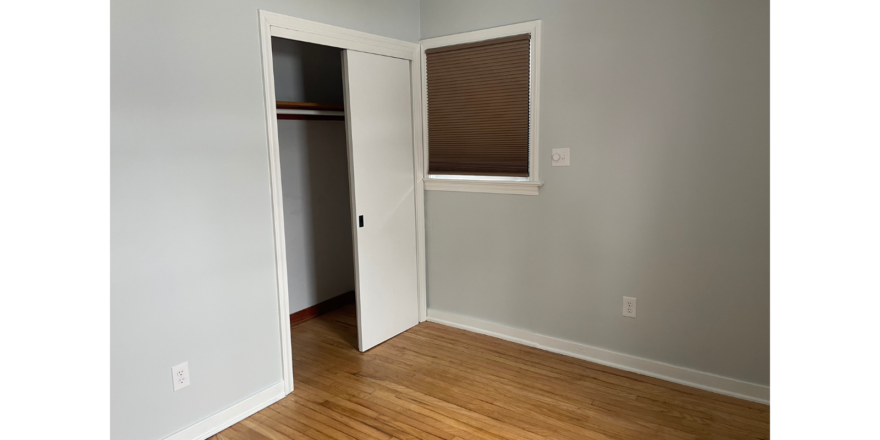 an empty room with a closet and a window