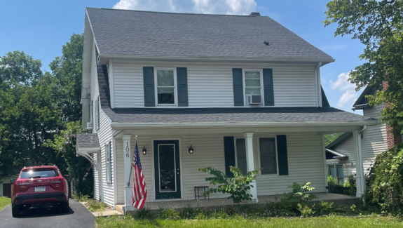 a car parked in front of a white house