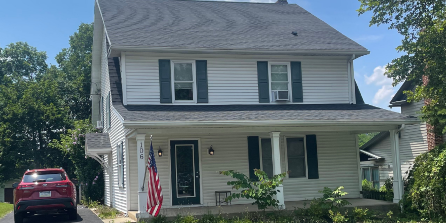 a car parked in front of a white house