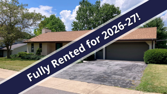 a house for sale with a blue ribbon in front of it