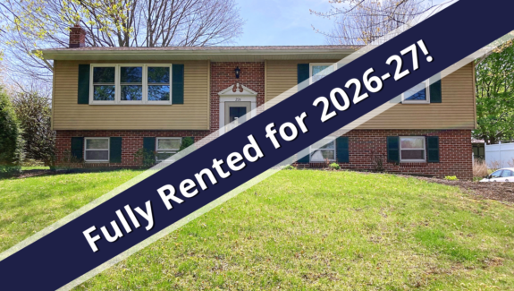 a house for sale with a blue ribbon in front of it