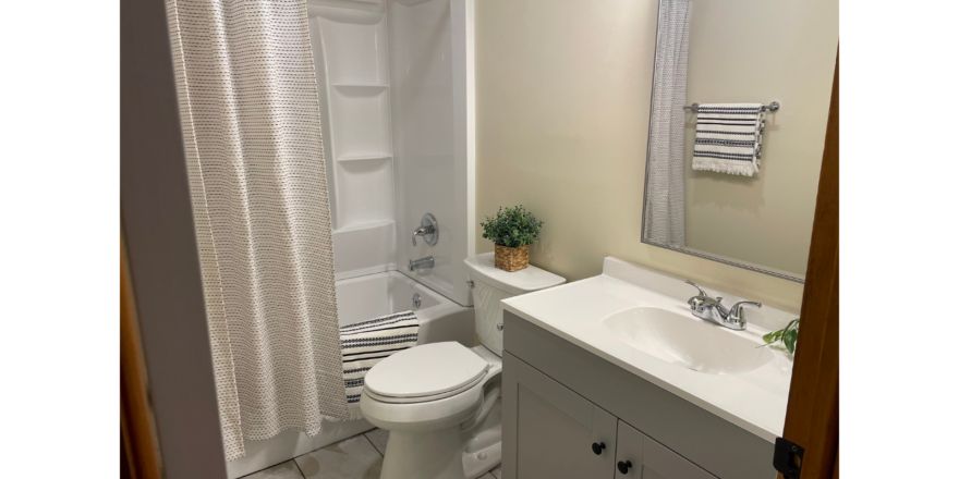 a bathroom with a toilet, sink, and shower