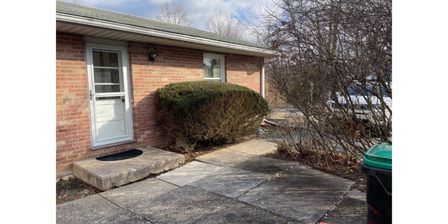 a small brick house with a white door