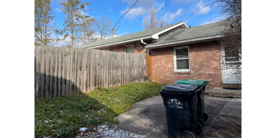 a trash can sitting in front of a house