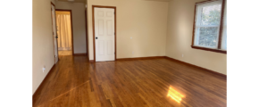 an empty room with wood floors and a door
