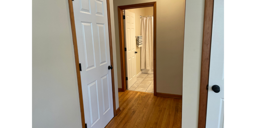 a hallway leading to a bathroom and a hallway leading to another room