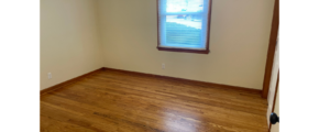a empty room with a wooden floor and a window
