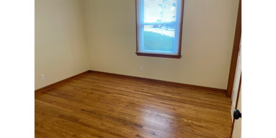 a empty room with a wooden floor and a window