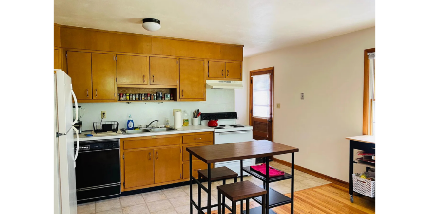 a kitchen with wooden cabinets and a table