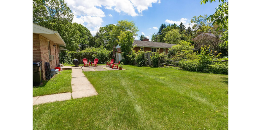 a yard with a lawn and a house in the background