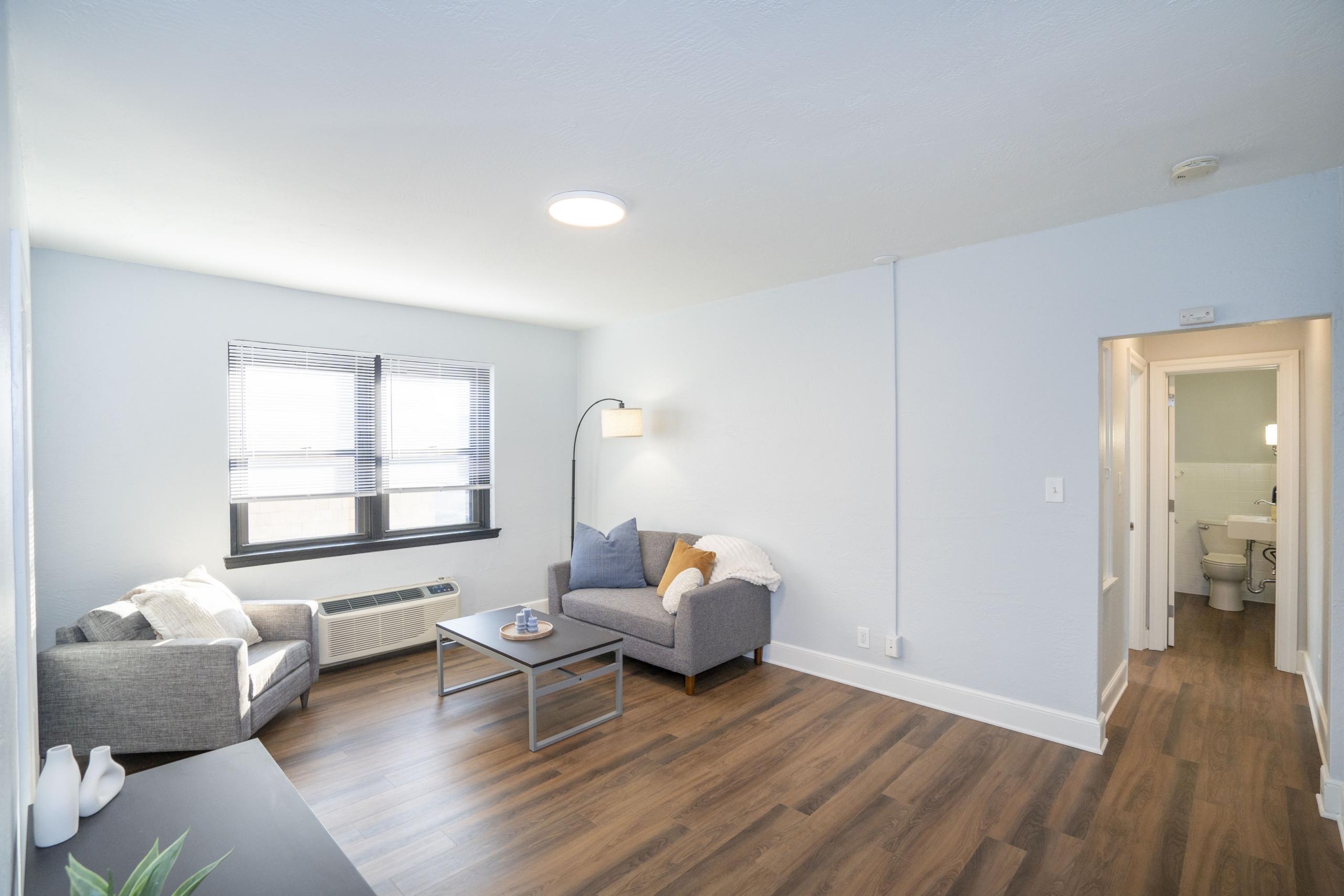 a living room with hard wood floors and white walls