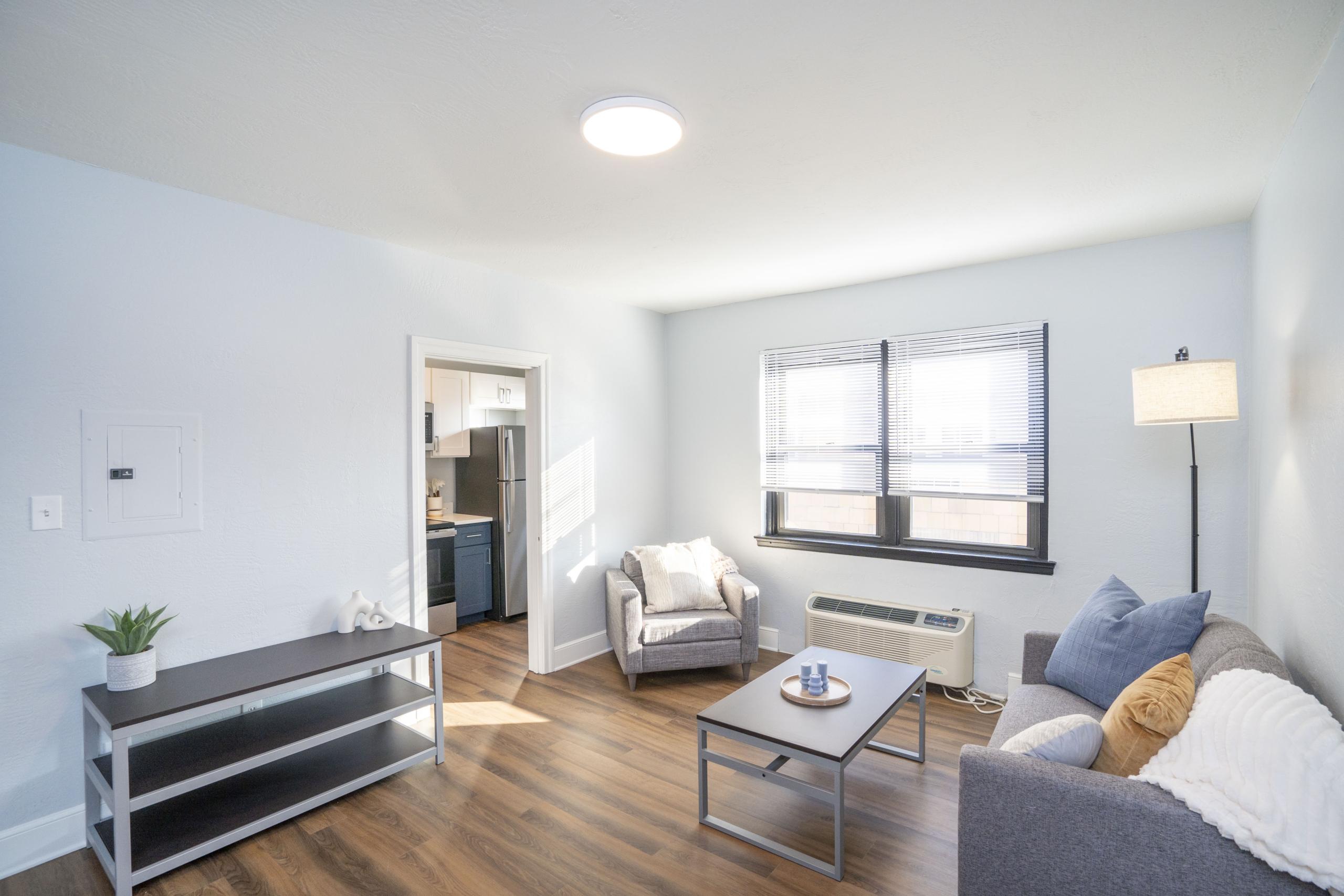 a living room filled with furniture and a hard wood floor