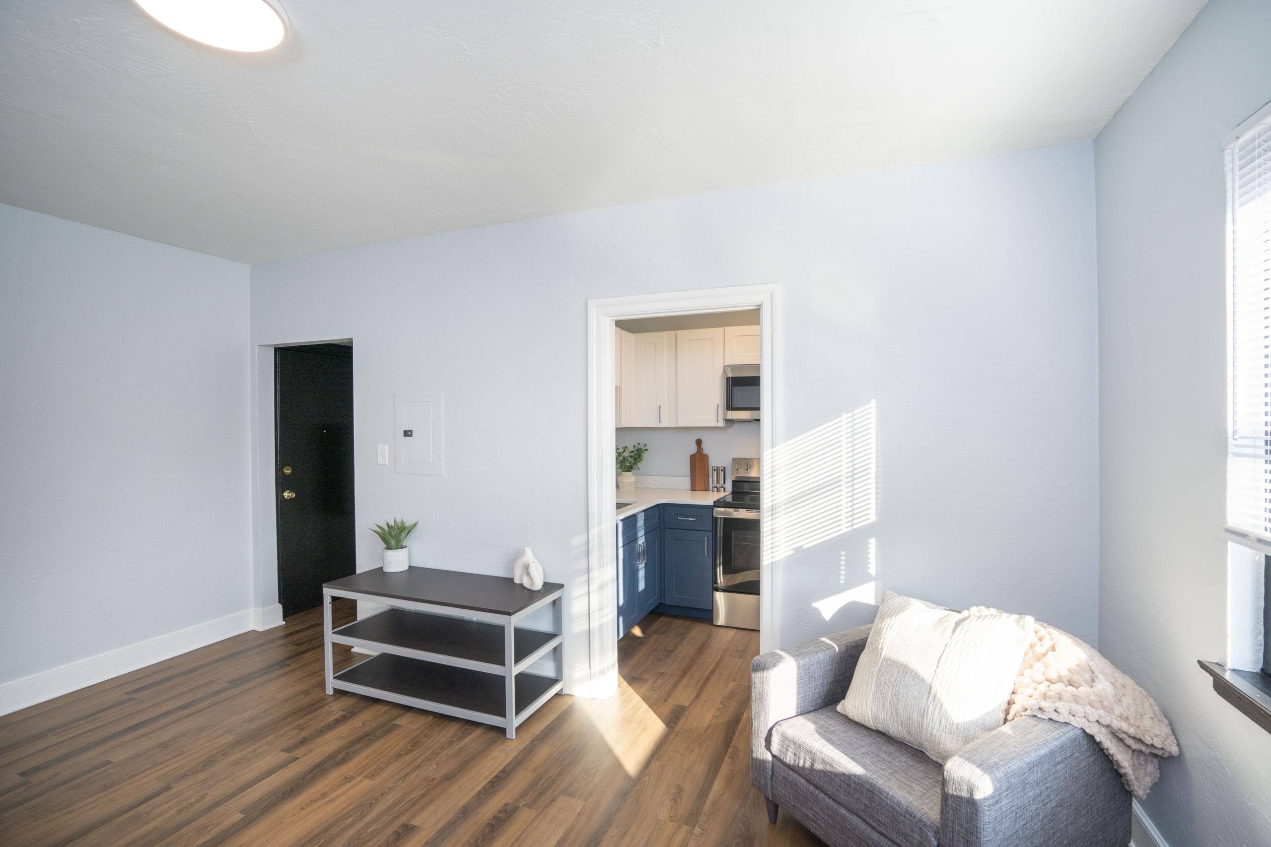 a living room with hard wood floors and white walls