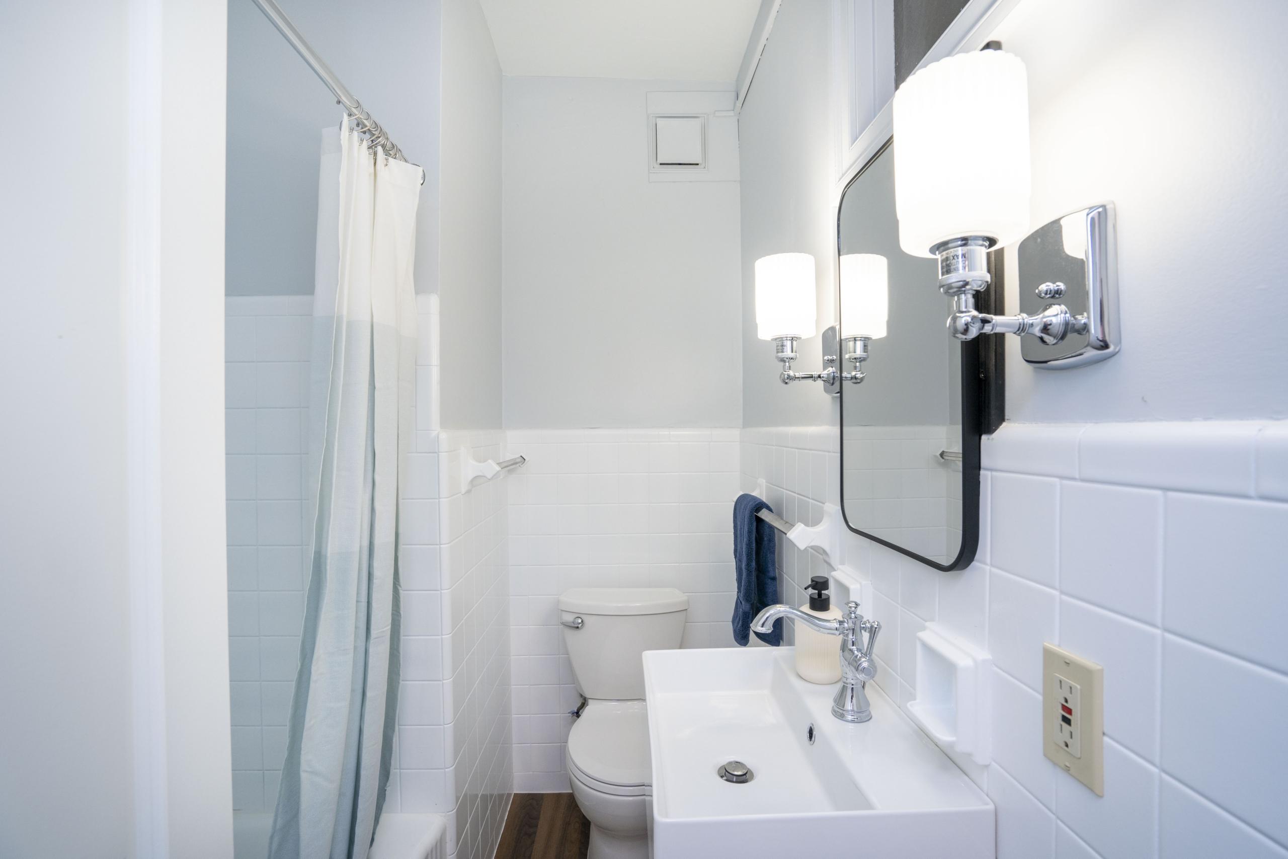 a bathroom with a sink, toilet, and shower