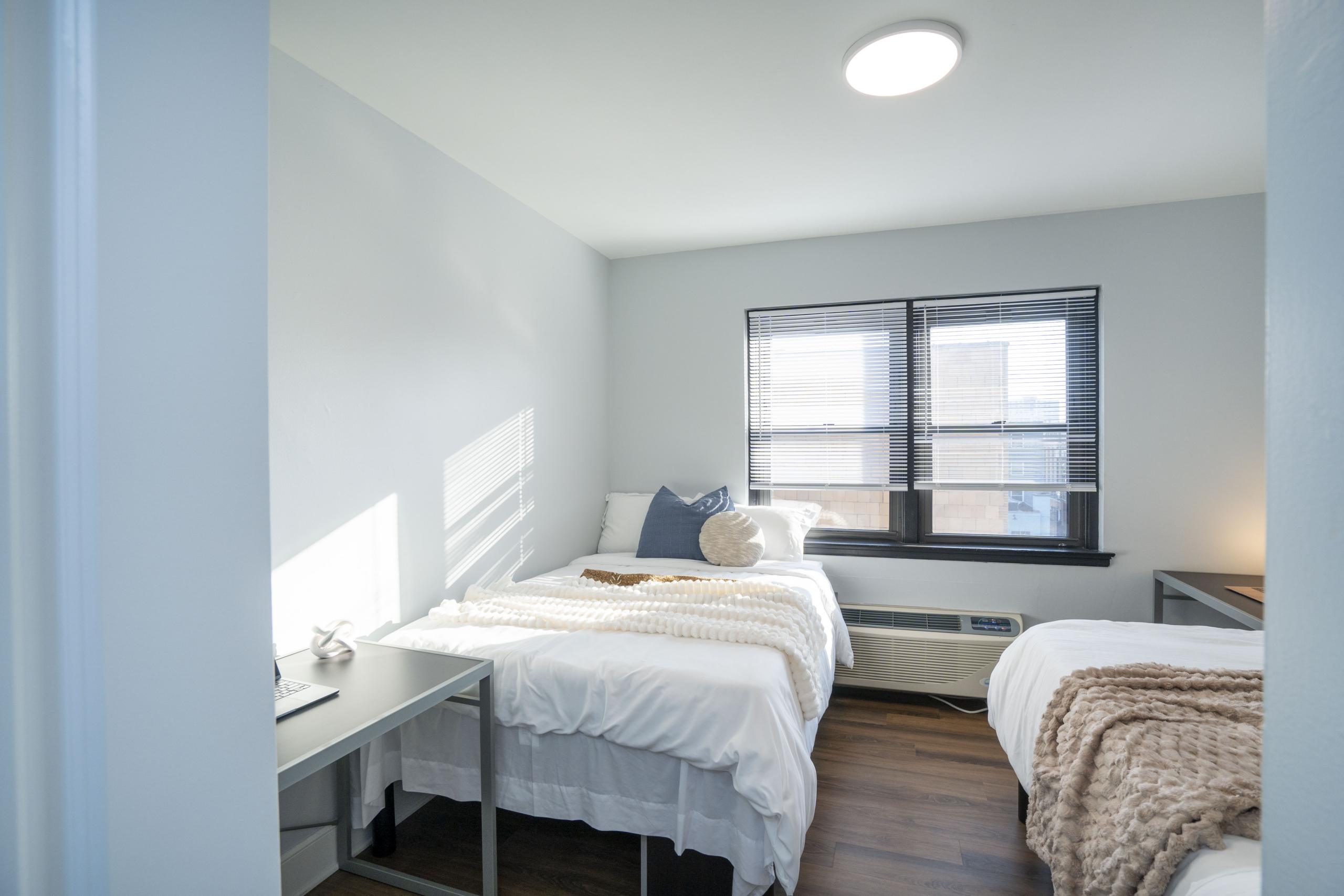 a bedroom with two beds and a desk