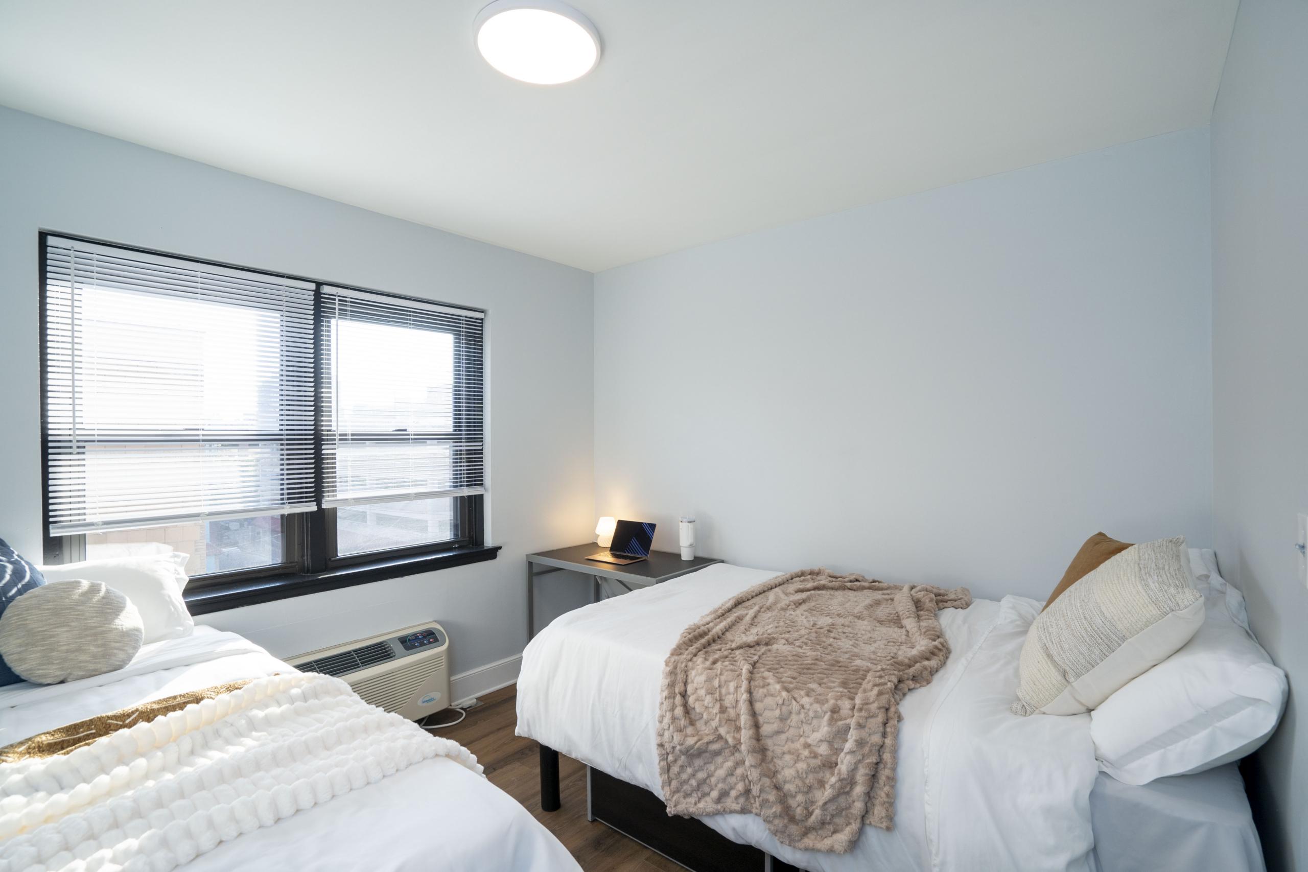 a bedroom with two beds and a window