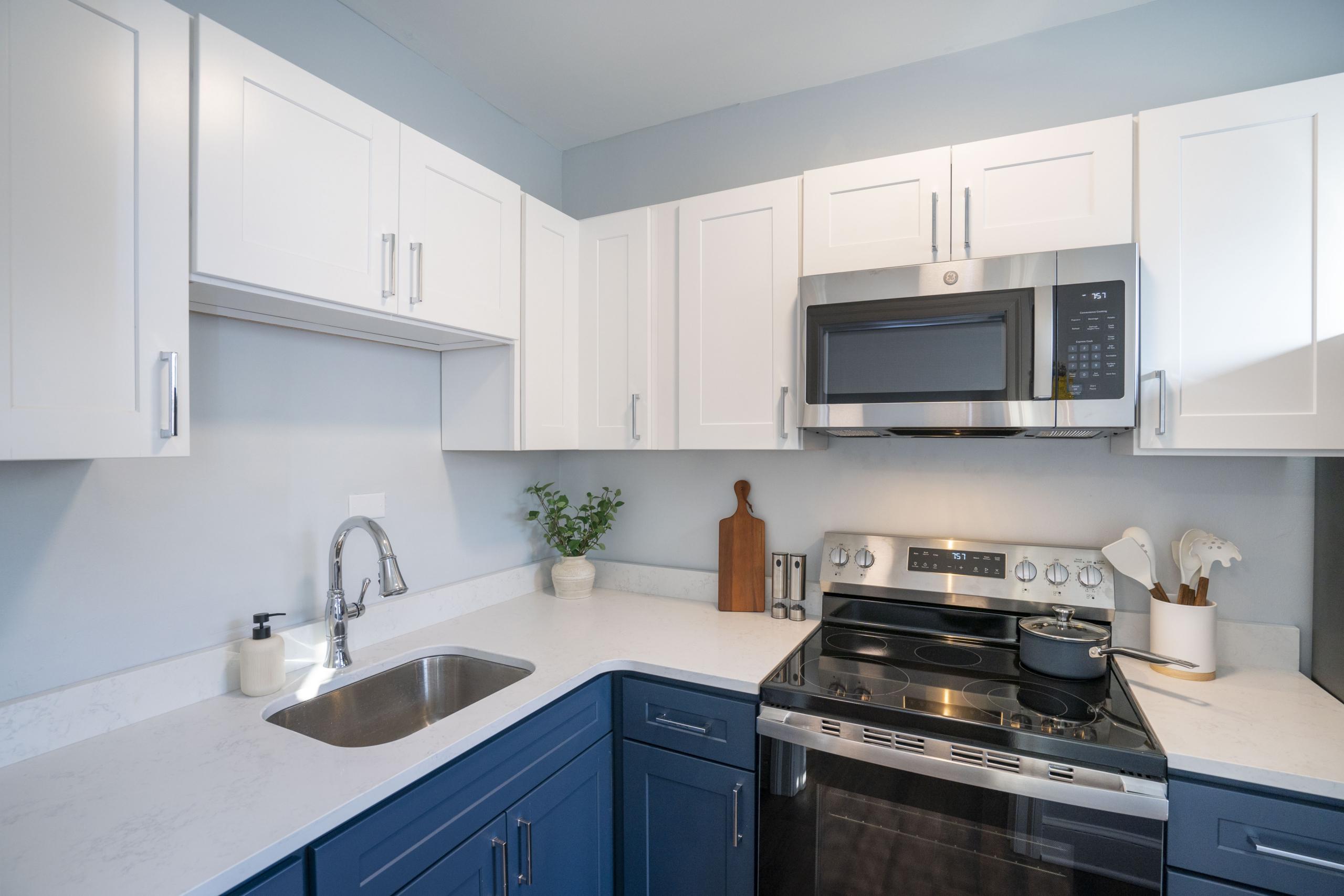 a kitchen with a stove, microwave and sink