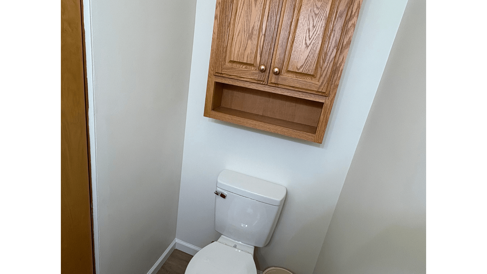 Toilet with wooden cabinet above