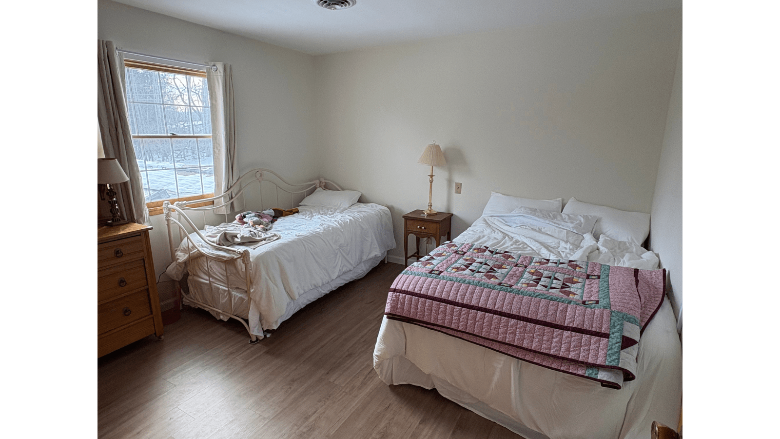Two beds in a bedroom with window