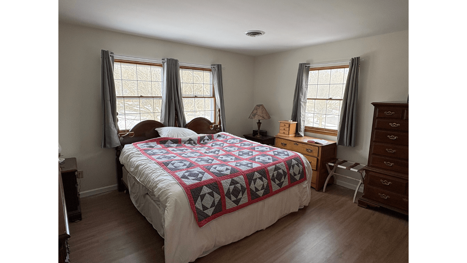 Cozy bedroom with quilt and dresser