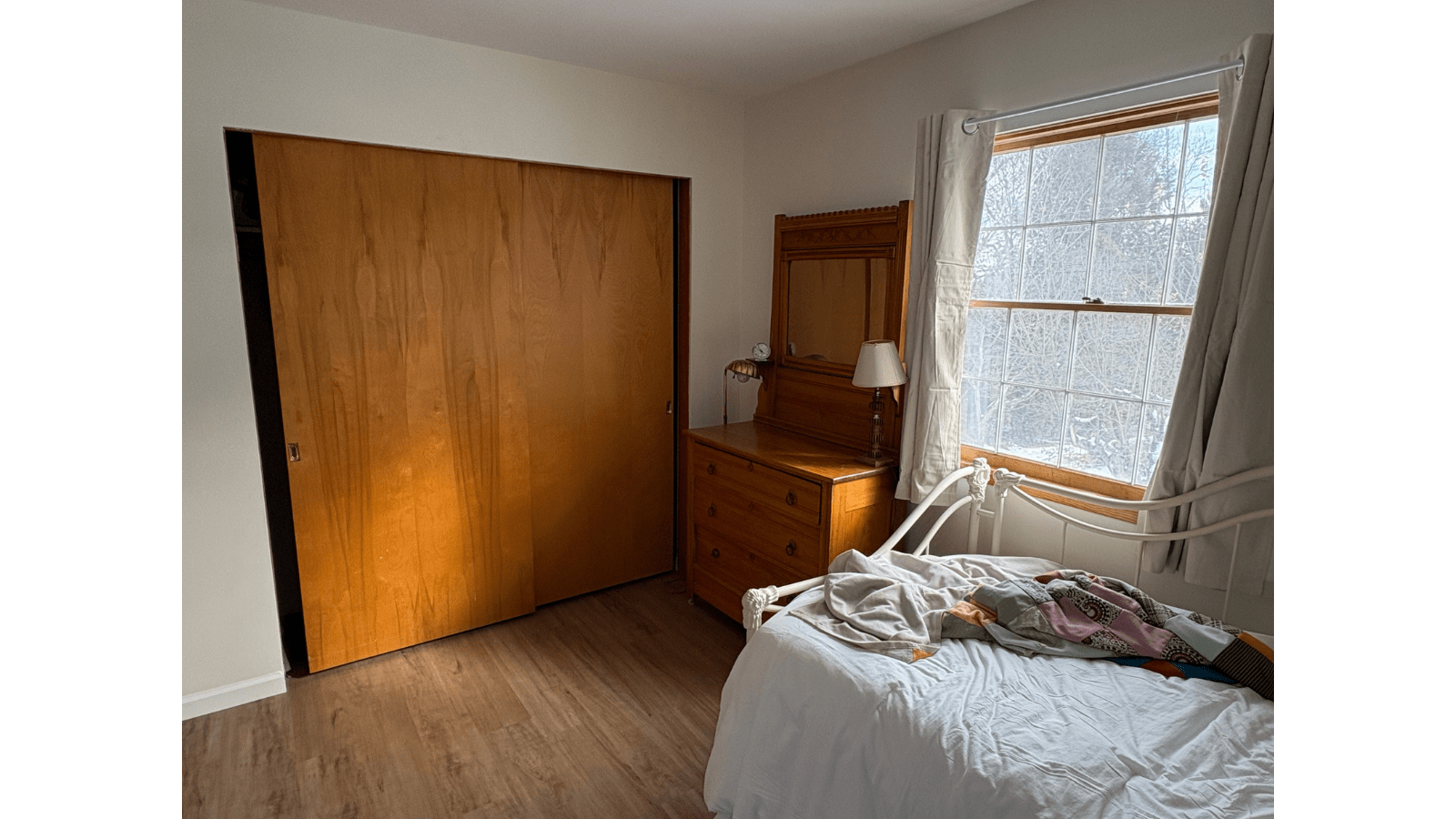 Bedroom with wooden sliding door and bed near window