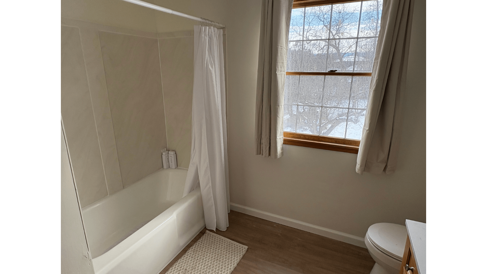 Bathroom with tub, window, and toilet