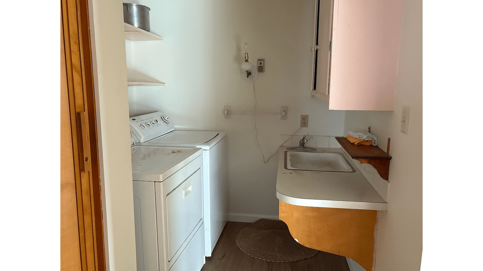 Laundry room with washer, dryer, sink, and cabinets.