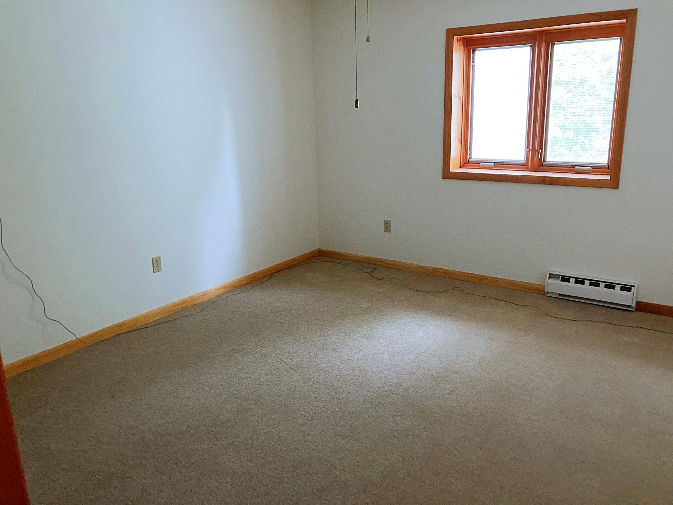 Empty bedroom with carpet and window