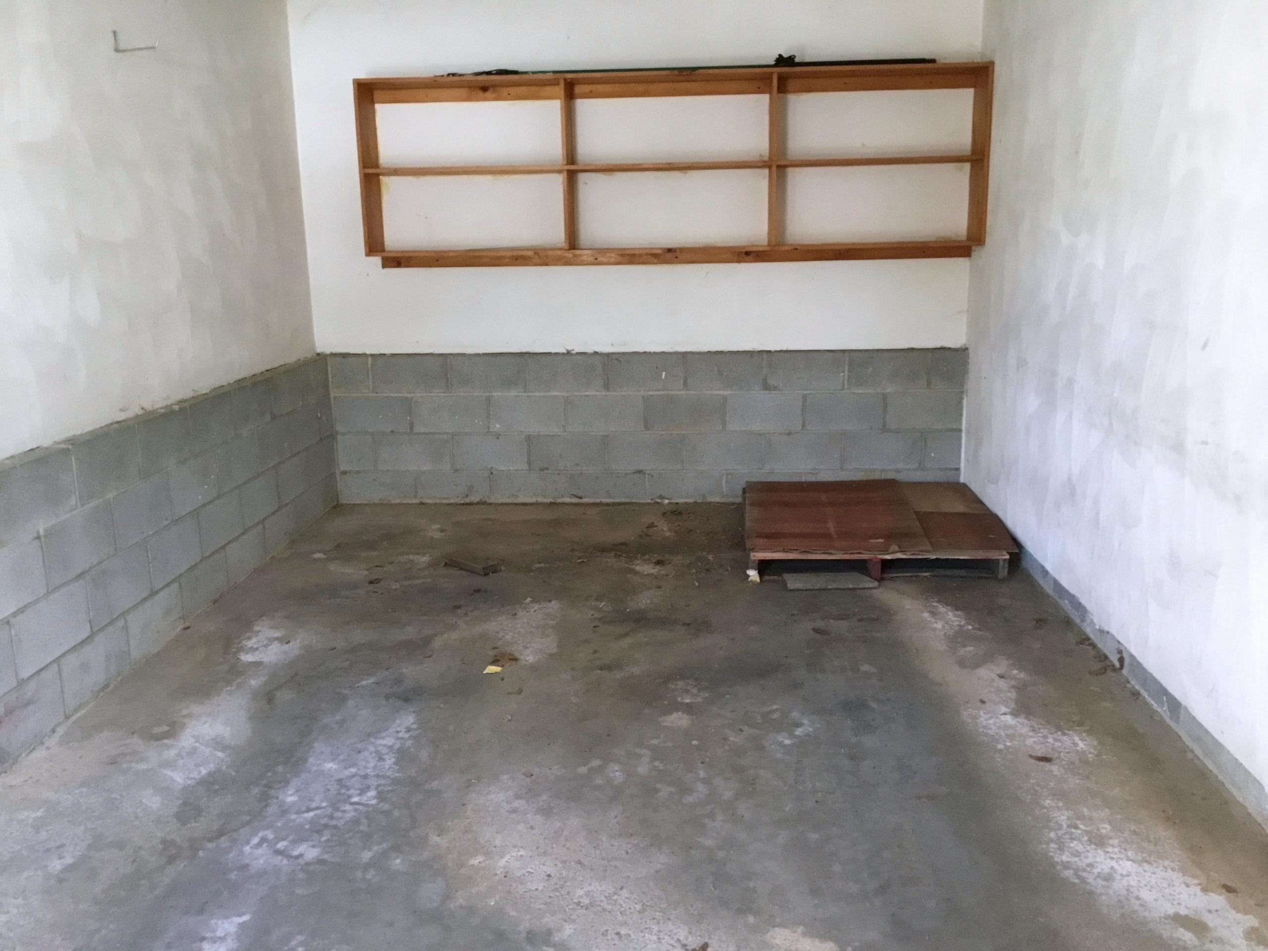 Empty garage with concrete floor and shelves