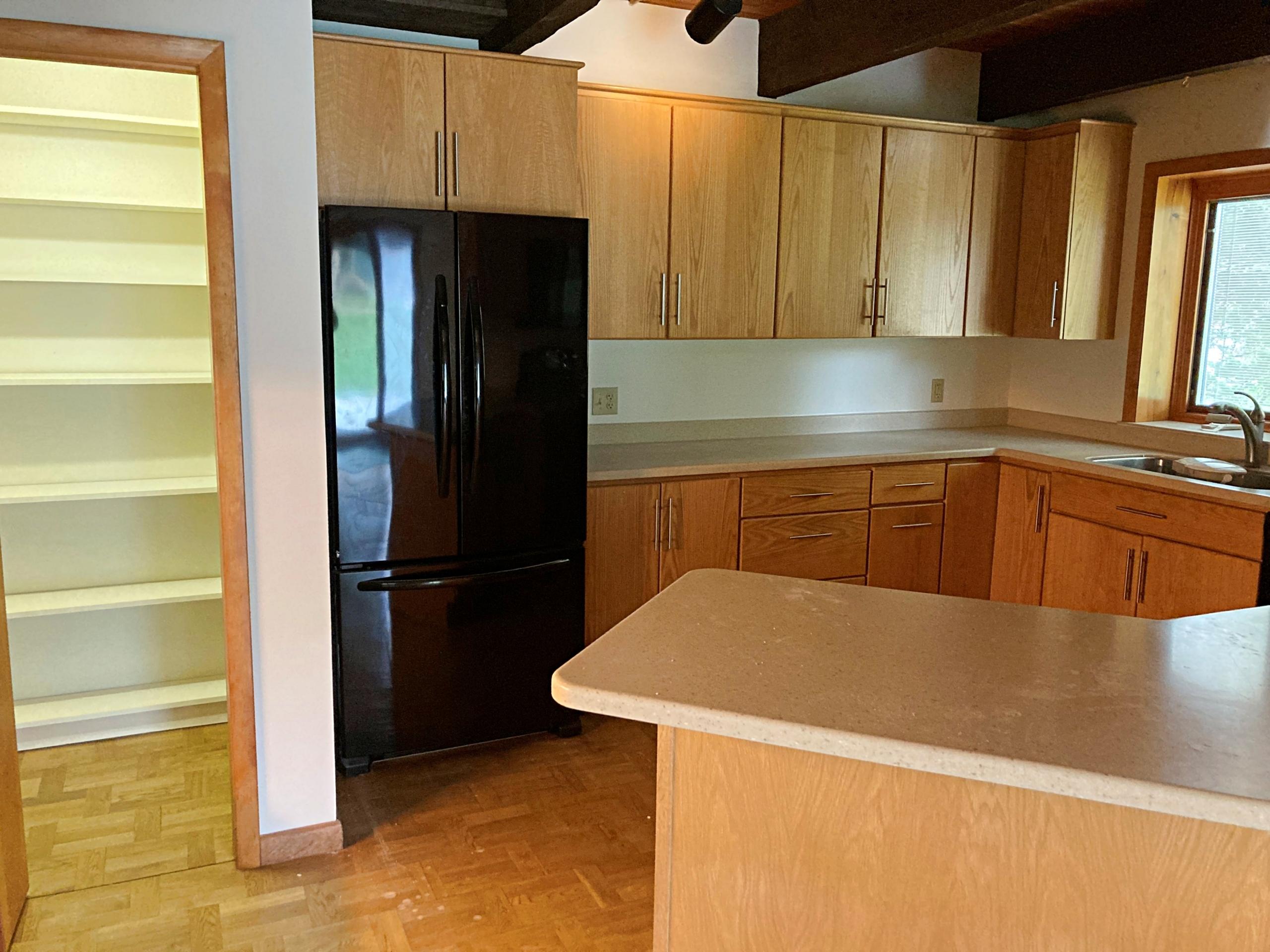 Light wood kitchen with black refrigerator