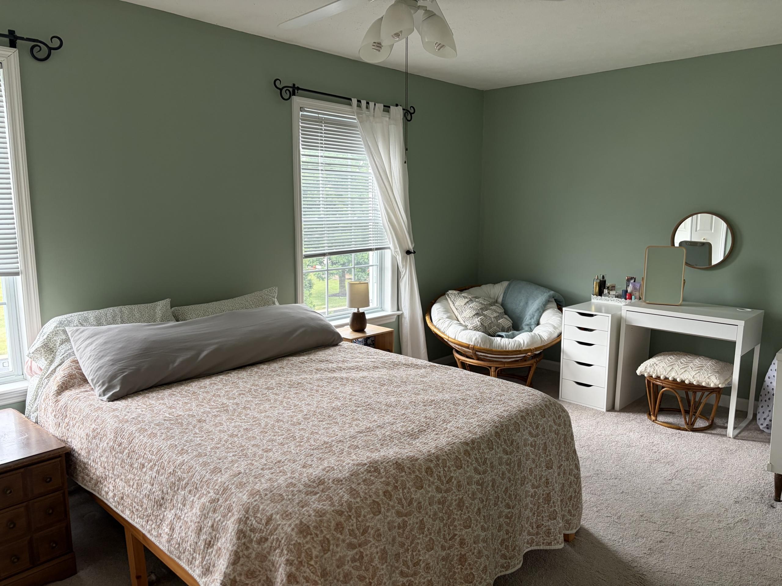 Bedroom with green walls and a papasan chair