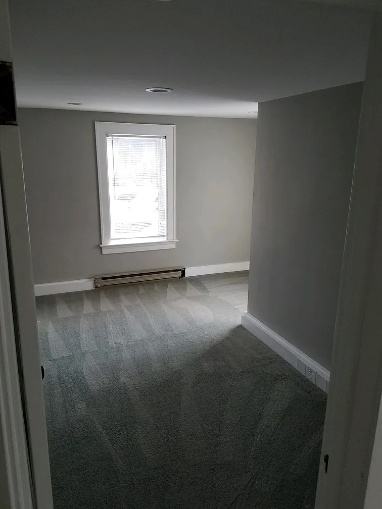 Empty bedroom with gray walls and carpet