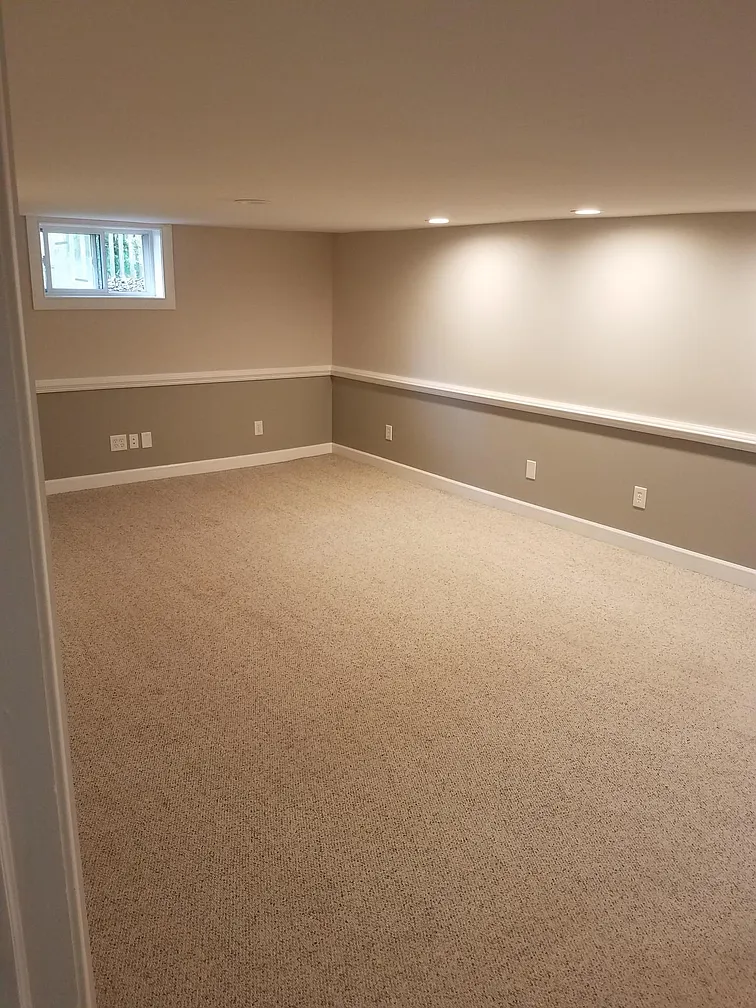 Finished basement with neutral carpet and walls