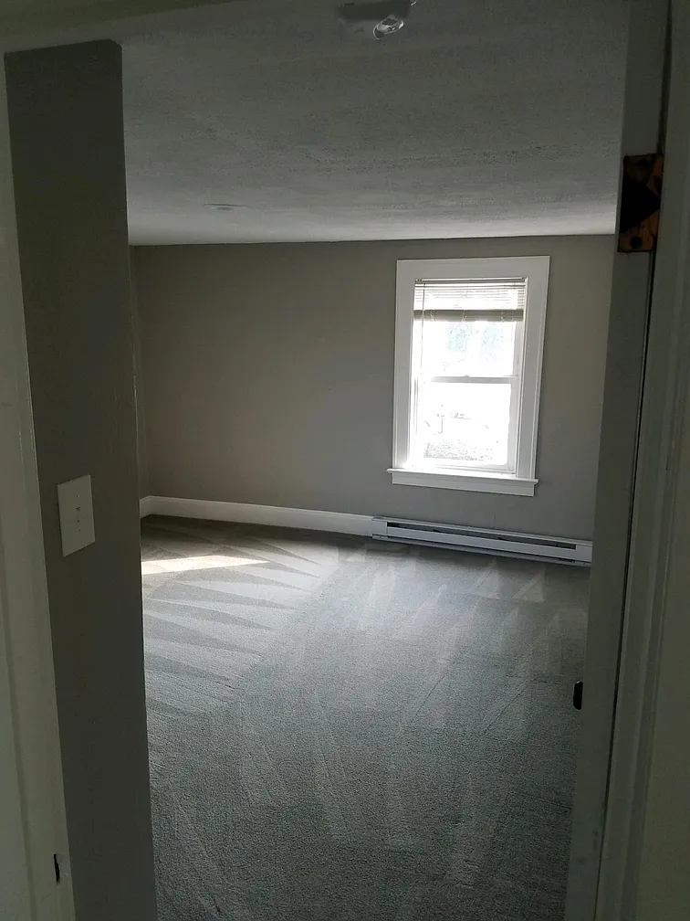 Empty bedroom with gray carpet and window