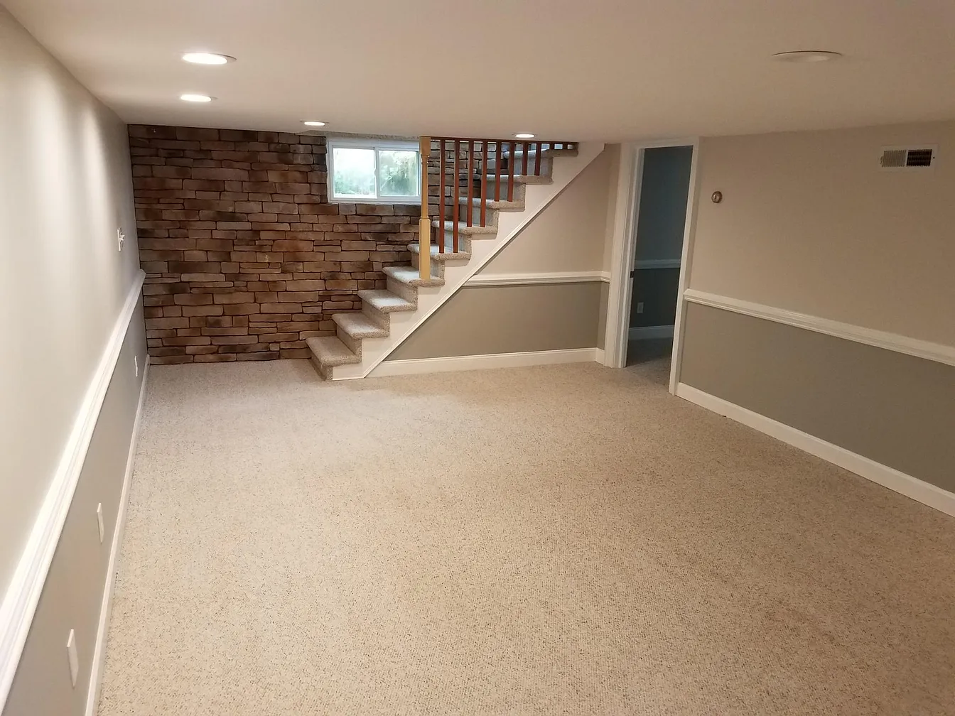 Finished basement with carpet and stone accent wall