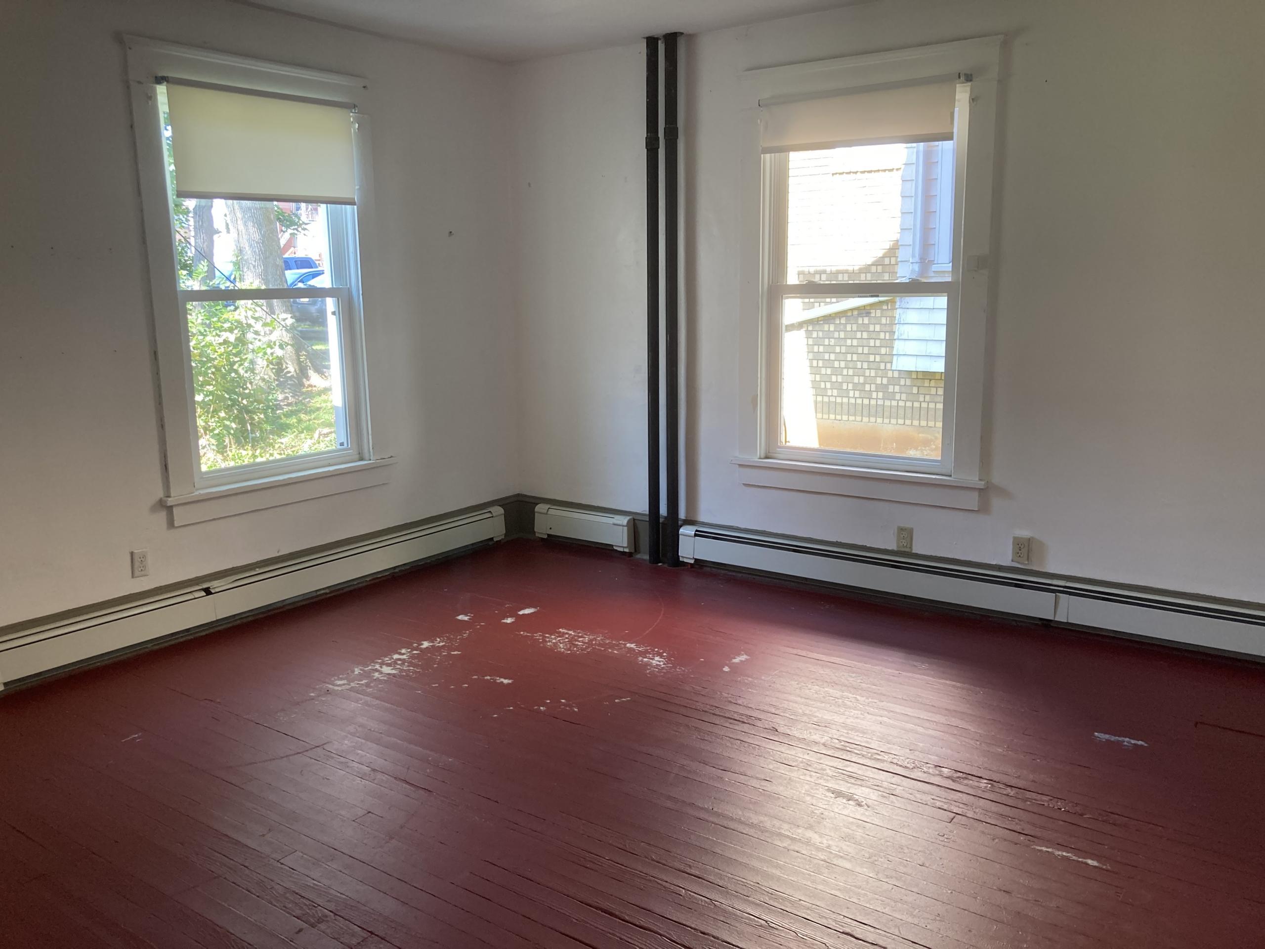 Empty room with red floor and two windows