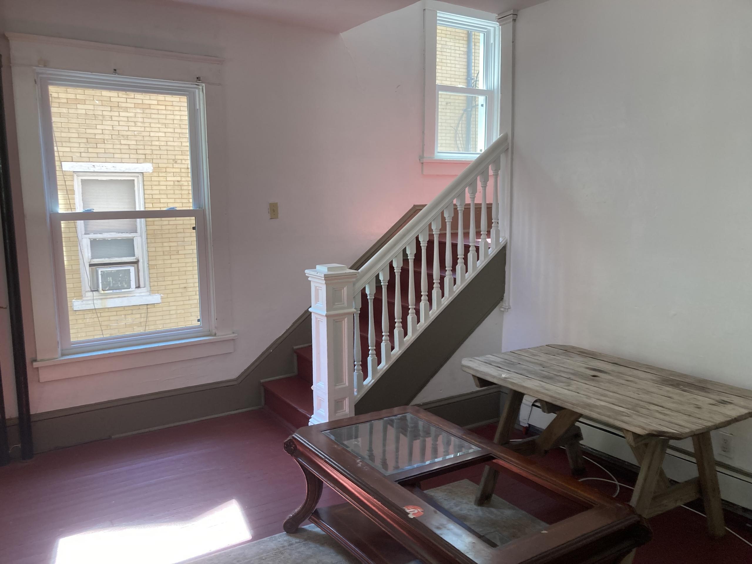 Interior staircase with red carpet and white railing