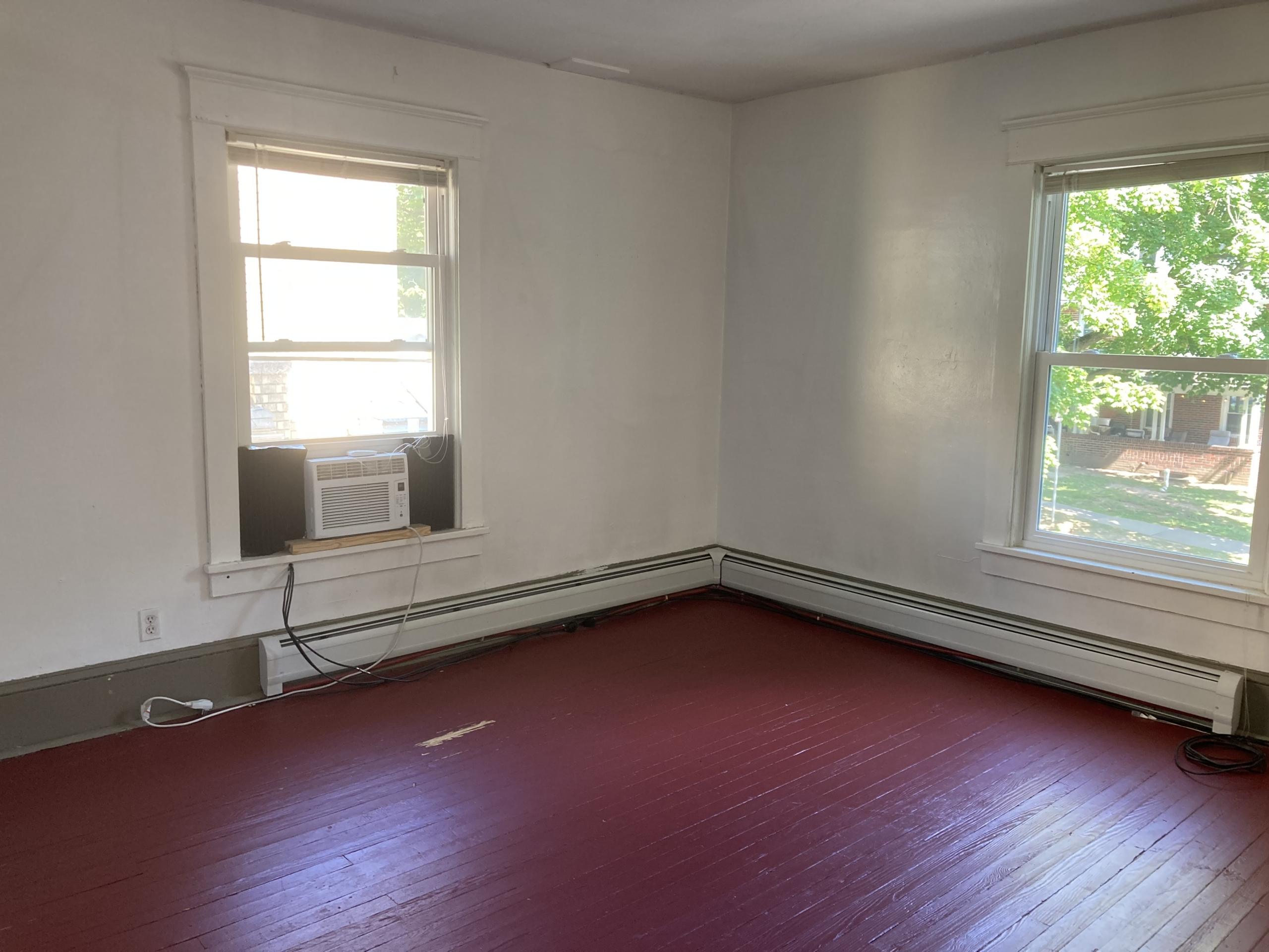 Empty room with red floor and two windows