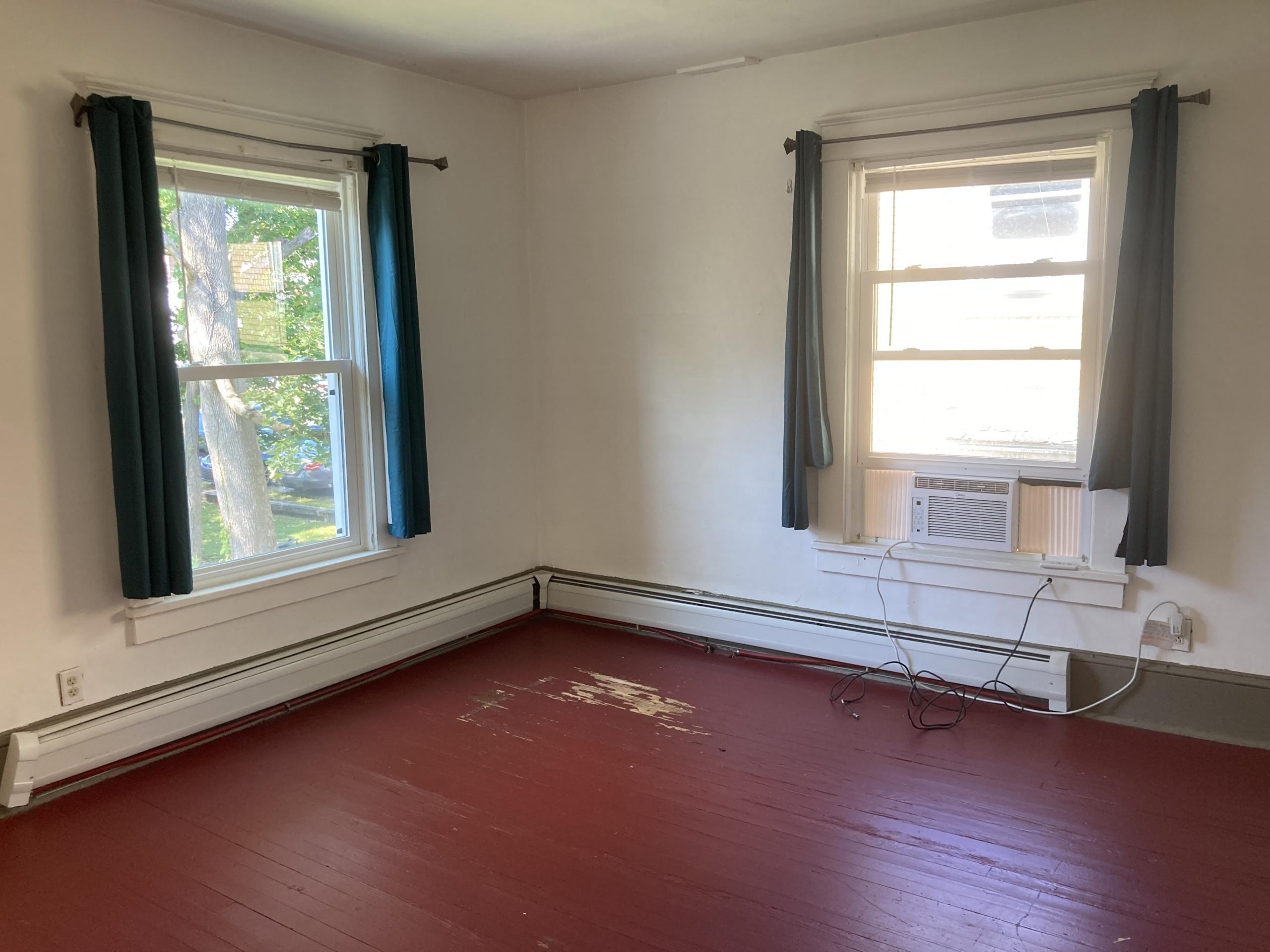 Empty room with red floor and two windows