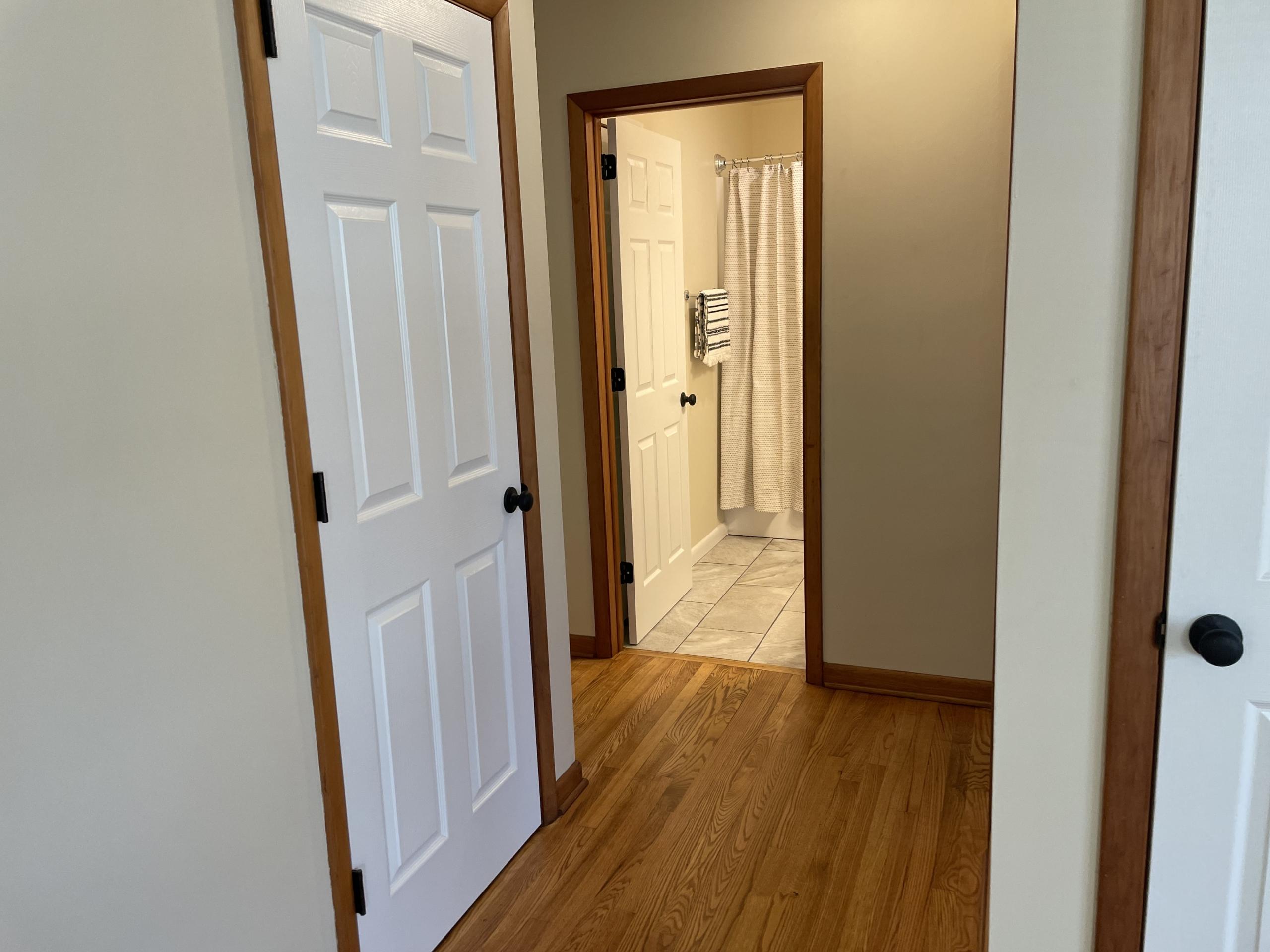 Hallway with white doors and wood floor