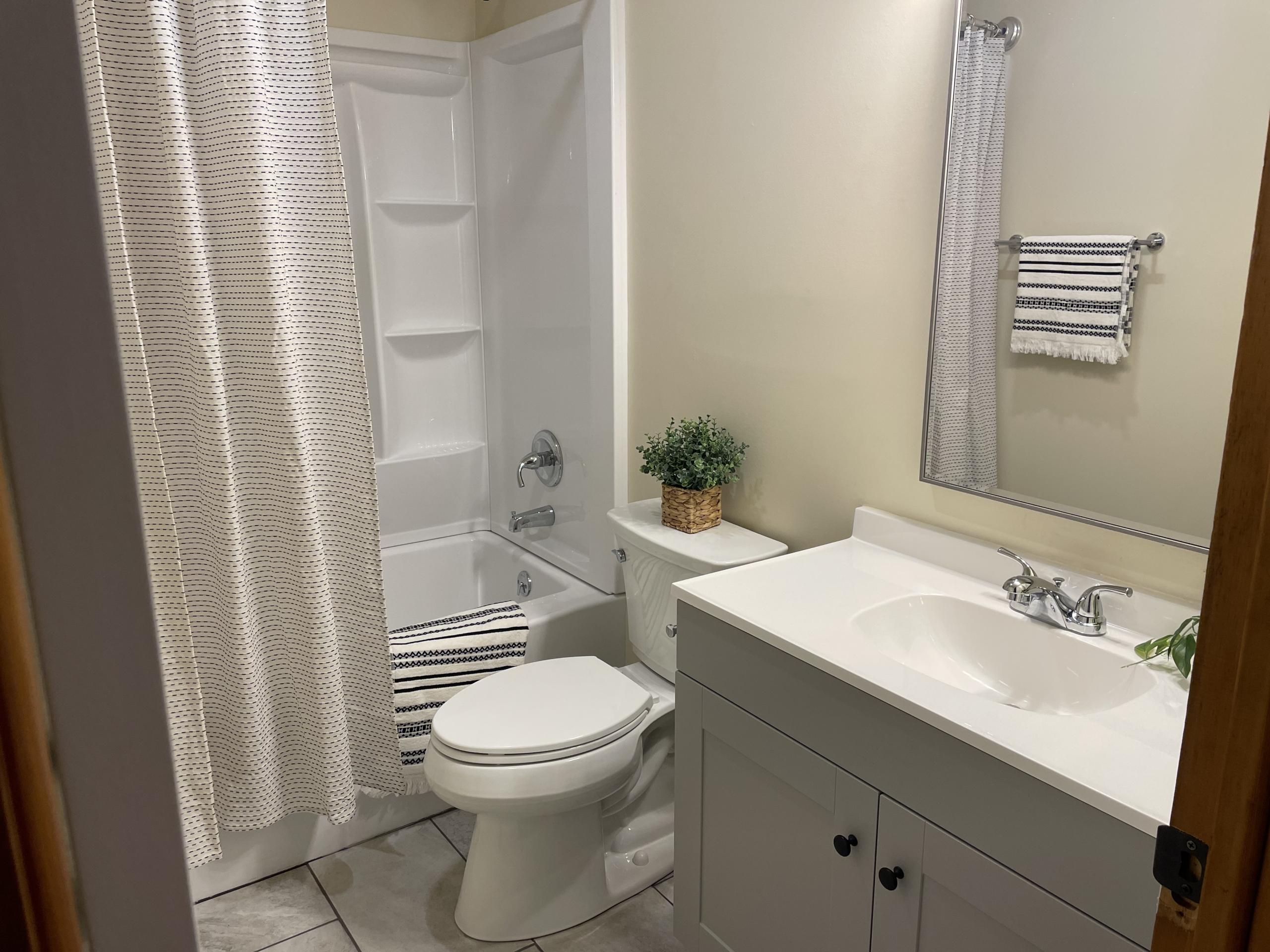Modern bathroom with vanity, toilet, and tub