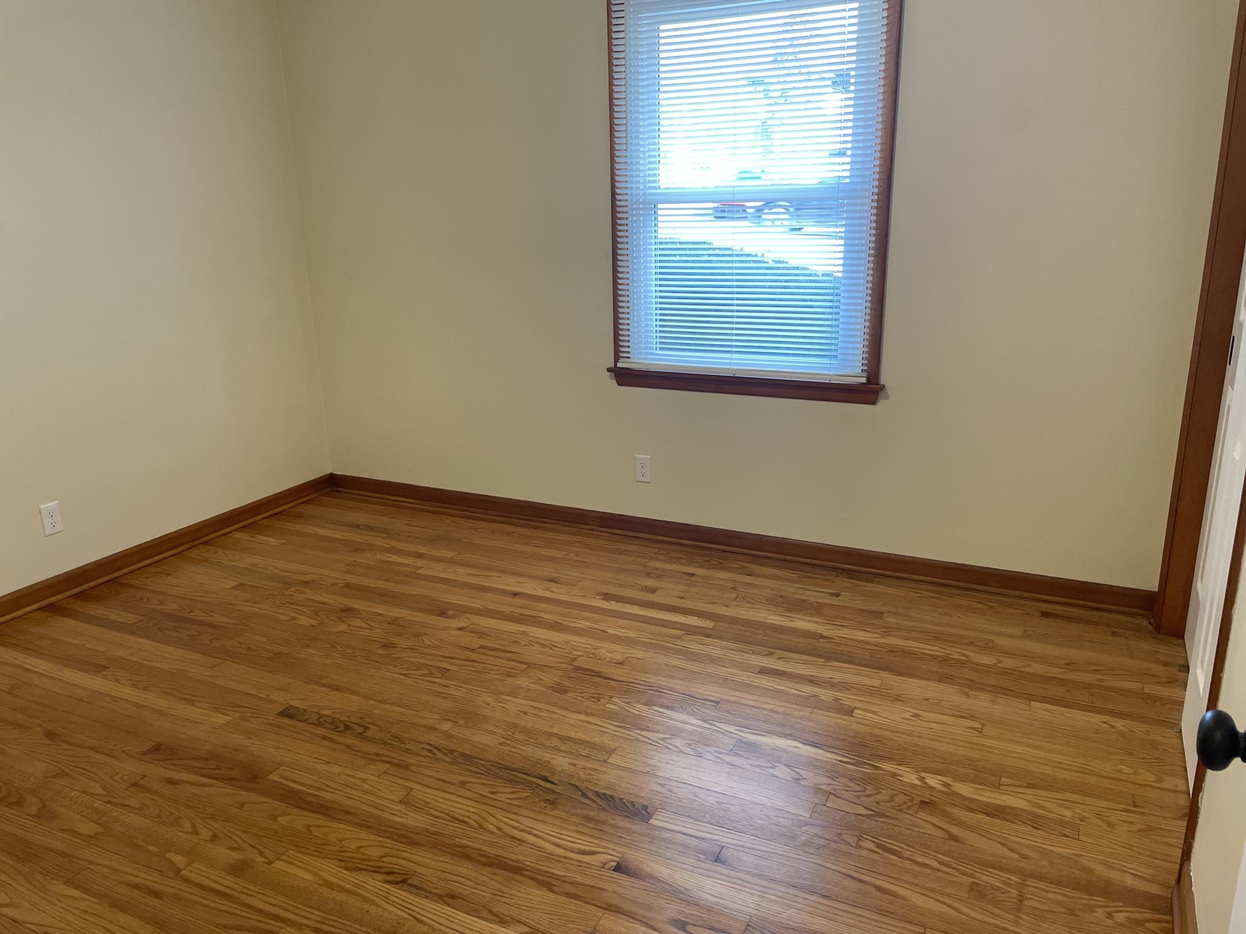 Empty room with hardwood floors and window