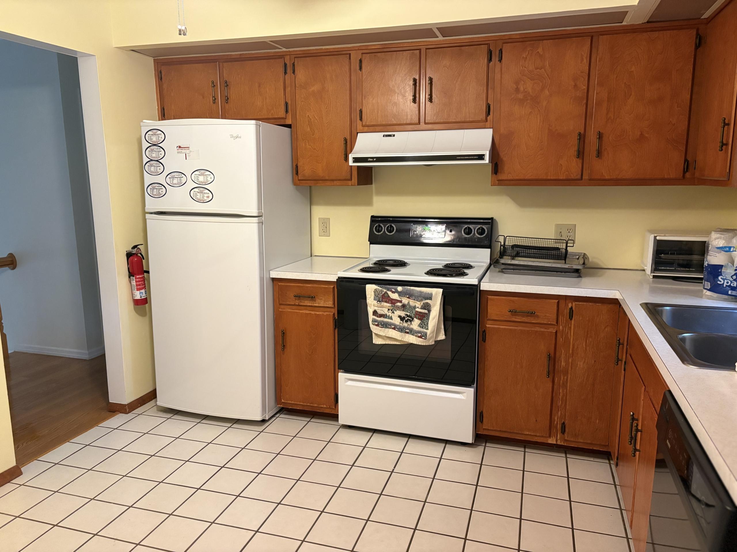 Kitchen with white refrigerator and wood cabinets