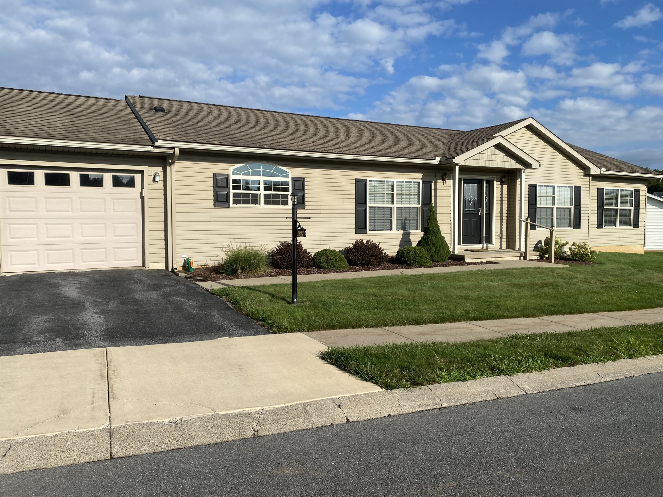 Exterior of a beige ranch home with garage