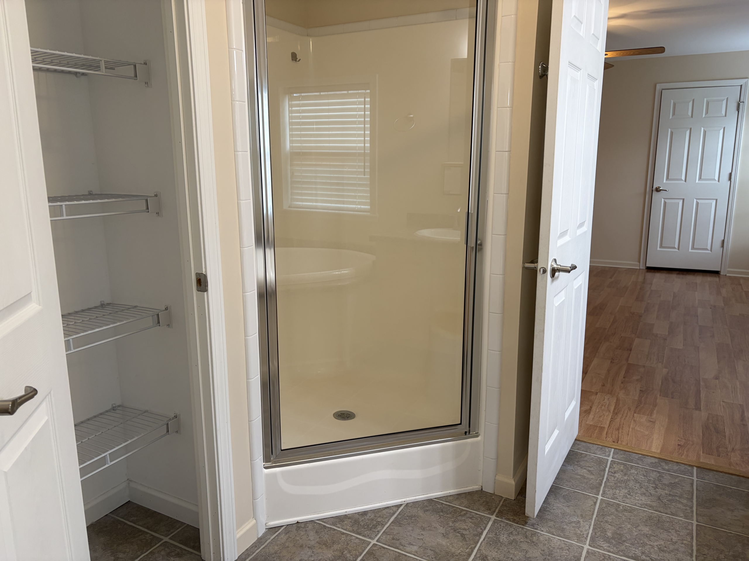 Bathroom with shower stall and storage shelves