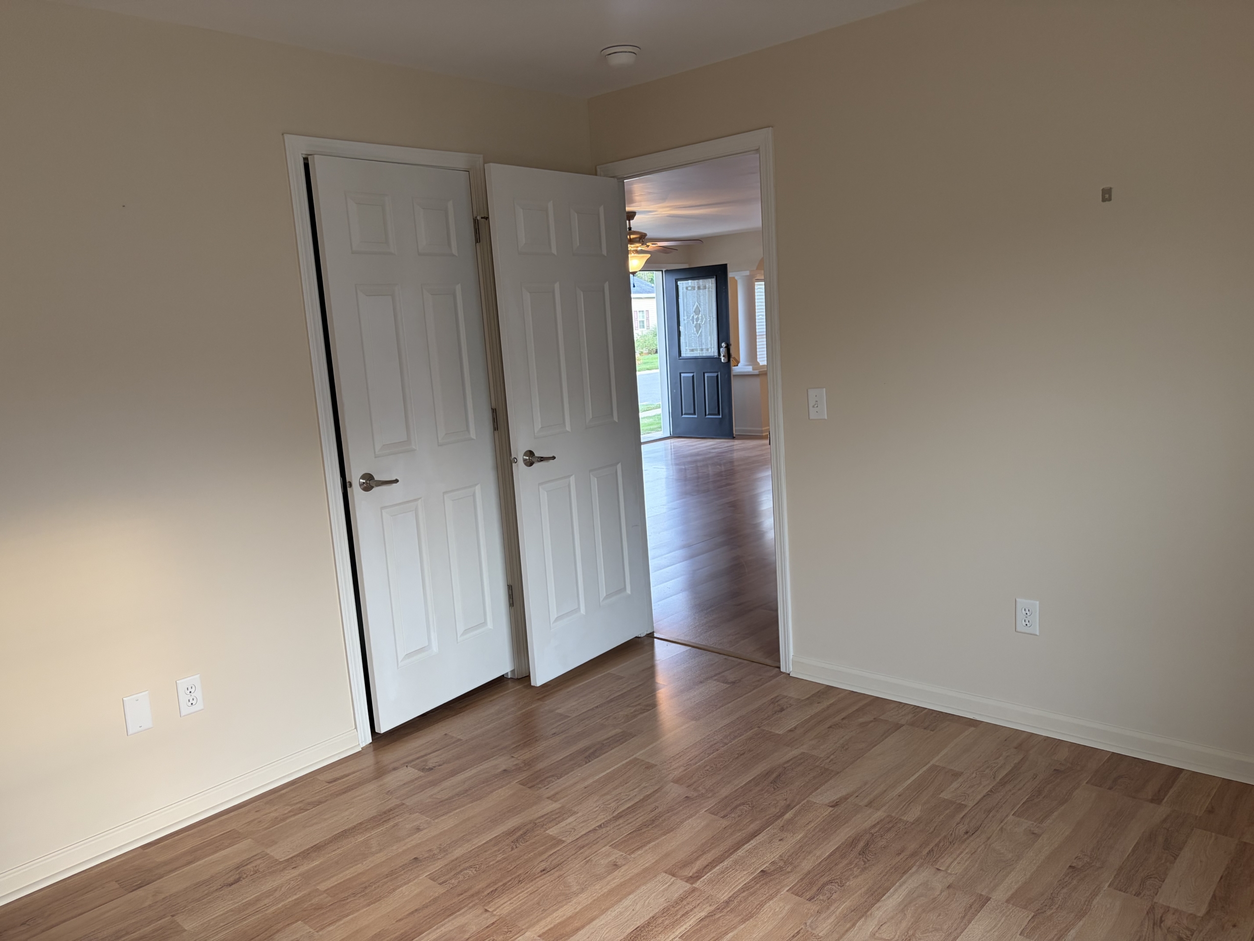 Open doors revealing living room and entryway